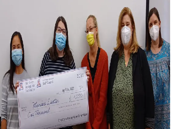 Group image of people displaying a big check they received